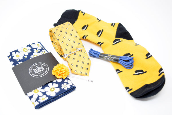 Pre-styled box with yellow and blue accents. Box comes with a pocket square, lapel pin, tie, tie bar, shoe laces, and socks.