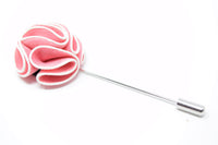 A pink and white flower lapel pin for a suit.