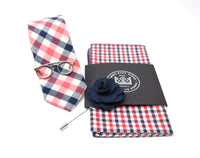 This pre-styled box comes with a navy and red checkered patterned tie and pocket square, polished silver glasses tie bar, and a navy flower lapel pin.